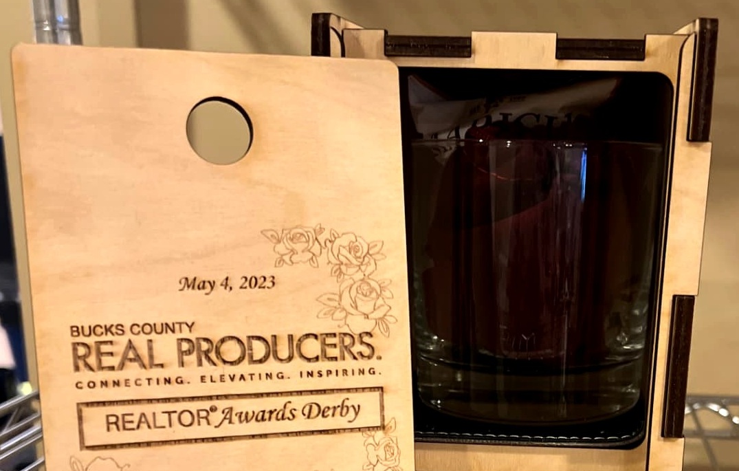 The sliding-lid presentation box open to reveal an engraved whiskey glass and branded interior tray